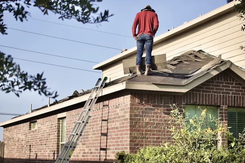 Professional roofer working on a residential roof in Belmont Center